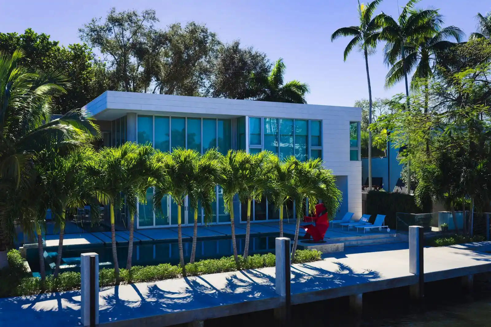 Modern mansion with a pool among palm trees